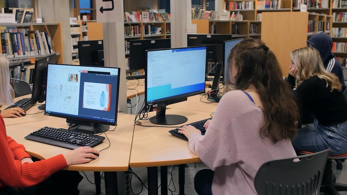 Elever i biblioteket som sitter ved pc - Klikk for stort bilde